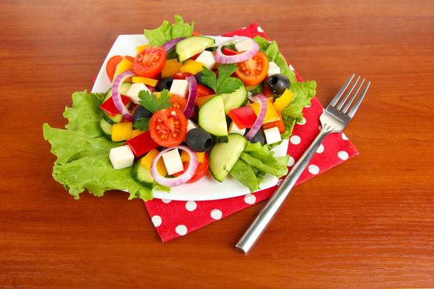 Ízletes görög saláta, fából készült háttér - Fotó, kép