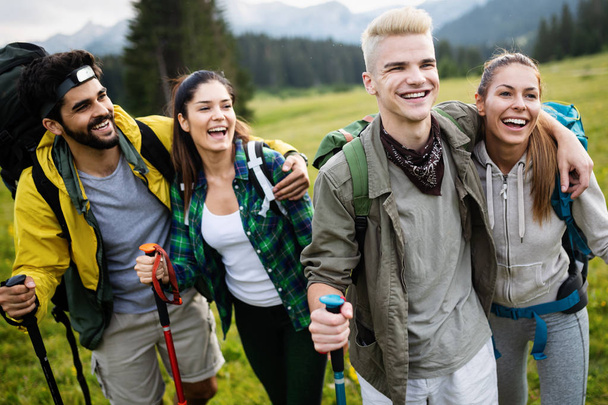 Hiking with friends is so fun. Group of young people with backpacks walking together and looking happy - 写真・画像