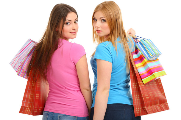 Две девушки подруги с магазинами изолированы на белом
 - Фото, изображение
