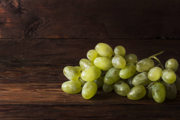 White Grapes on a wooden background with water splashes. Fresh fruit concept, new crop. - Foto, Imagen