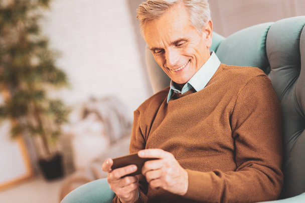 Aged man enjoying communicating via video chat - Фото, изображение