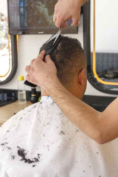 Close-up, cabeleireiro mestre faz corte de cabelo e estilo com a tesoura e pente. Conceito Barbearia
. - Foto, Imagem
