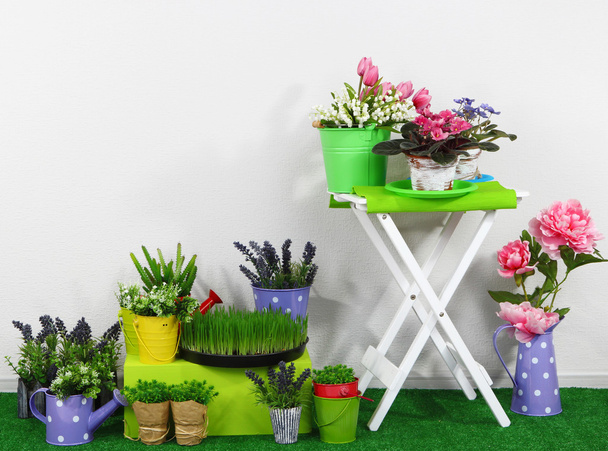 Color crate and table with decorative elements and flowers standing on grass - Foto, Imagem