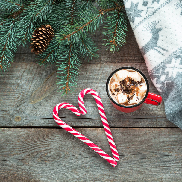 Christmas mug of hot coffee with marshmallow, candy cane on wooden board. New Year. Top view and copy space. - Фото, зображення