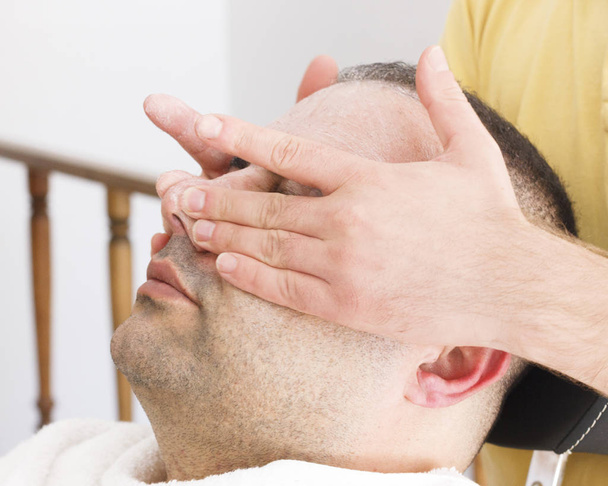 Facial massage for turkish man in barber shop - 写真・画像
