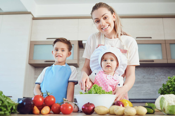 Mother and children are cooking in the kitchen - Foto, Bild