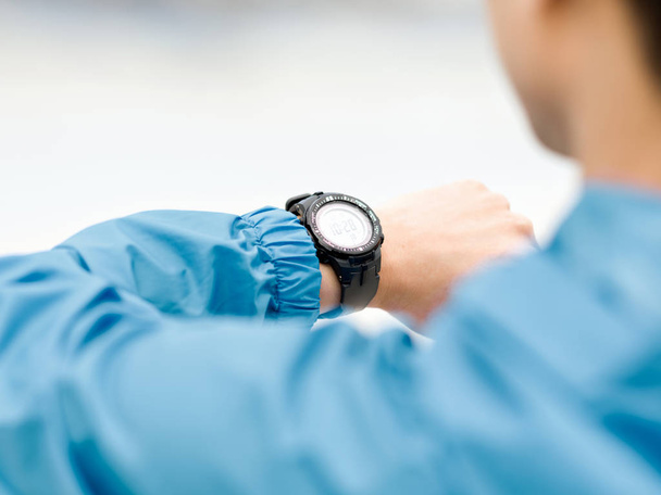 Молодий чоловік у спортивному одязі за допомогою смарт-годинника
 - Фото, зображення