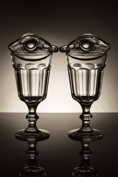 Set of wine glasses and glass sauce cups on darken background - Foto, afbeelding