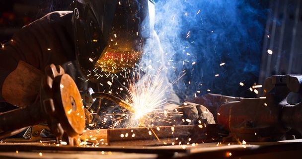 Welder working in workshop factory. Heavy industrial and manual working concept - Photo, Image