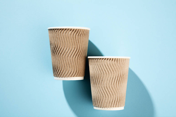 Maqueta de taza de café de papel para llevar aislada sobre fondo azul. Concepto foto de la taza de café. Espacio libre de copia en blanco vacío para su texto de diseño o banner de marca. Colores de tendencia
 - Foto, Imagen
