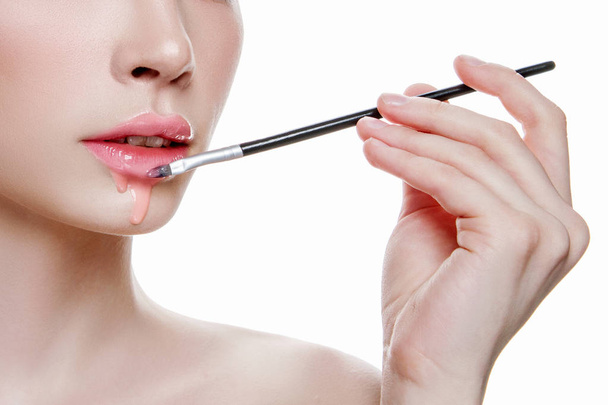 mujer con gel en los labios. hermosa chica aplicando maquillaje cosmético. Concepto de maquillaje
 - Foto, Imagen