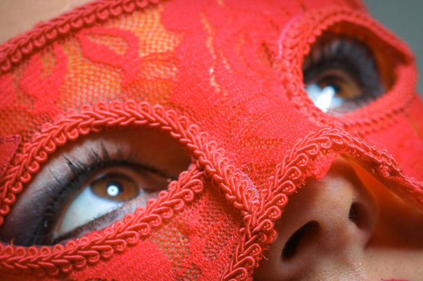 Primer plano retrato de mujer sexy en rojo, máscara de fiesta de oro para el concepto de deseo en Año Nuevo y fiesta de Navidad
 - Foto, imagen