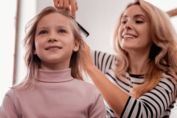 Careful mother making a hairstyle - Photo, Image