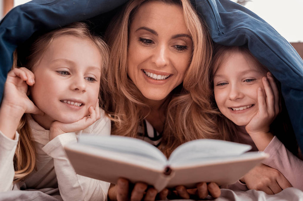 Nice mother and daughters reading a book - Foto, Imagem