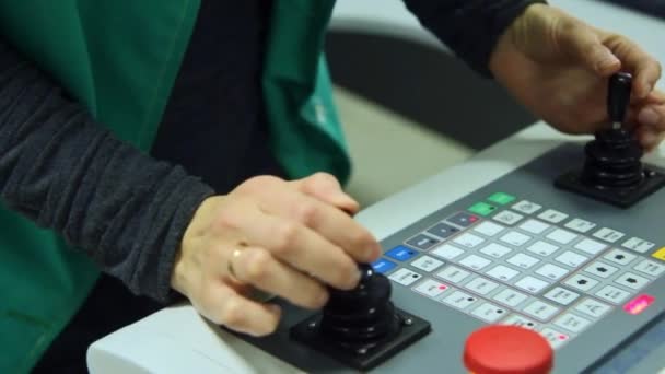 Arbeiter steuert Produktionsprozess mit zwei Steuerknüppeln am Bedienpult - Filmmaterial, Video