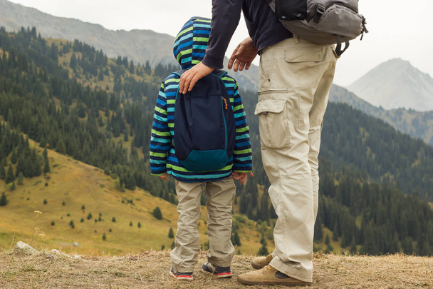 padre con hijo rastreando juntos en altas montañas
 - Foto, imagen