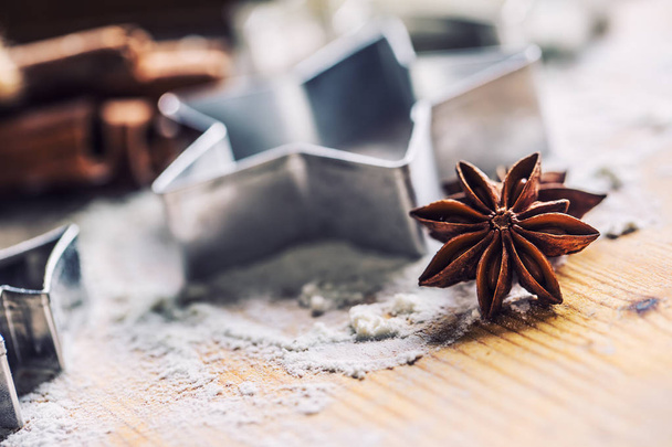 Star anise cookie cutter cinnamon and flour on baking board. Christmas baking utensil and holiday concept. - Foto, Imagen