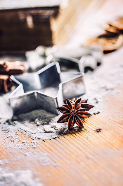 Star anise cookie cutter cinnamon and flour on baking board. Christmas baking utensil and holiday concept. - Foto, imagen