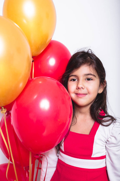 Baby Girl Holding Balloons celebrating her Birthday - Фото, изображение