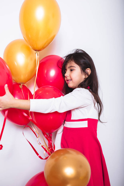 Baby Girl Holding Balloons celebrating her Birthday - 写真・画像