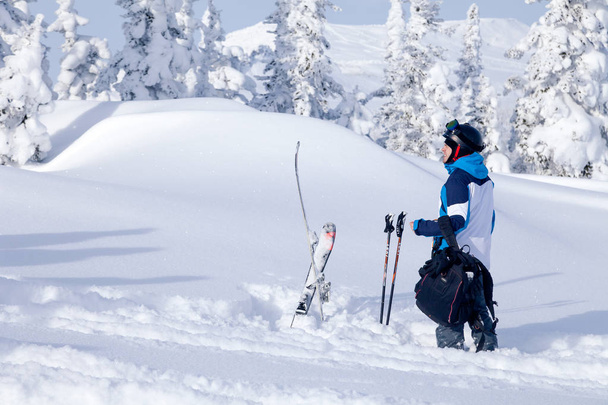 Rusland, Sheregesh 2018.11.78 professionele skiër in heldere sportkleding en outfit staat in besneeuwde zonnige hoge bergen. Concept freeride, gevaar sport - Foto, afbeelding