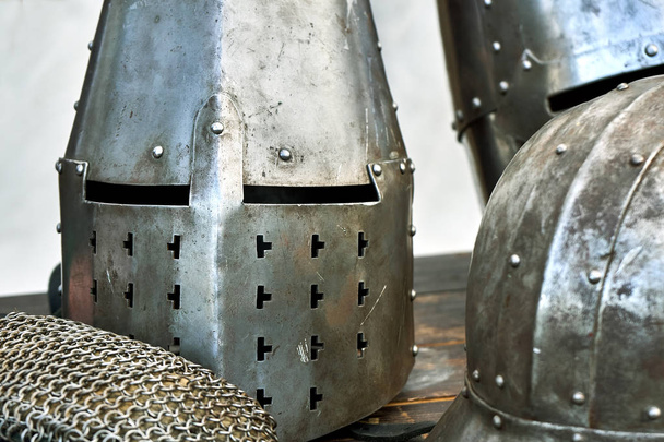 Stalen middeleeuwse helmen met ogen spleten op tafel - Foto, afbeelding