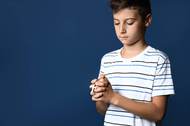 Little boy praying on color background - Foto, Imagen