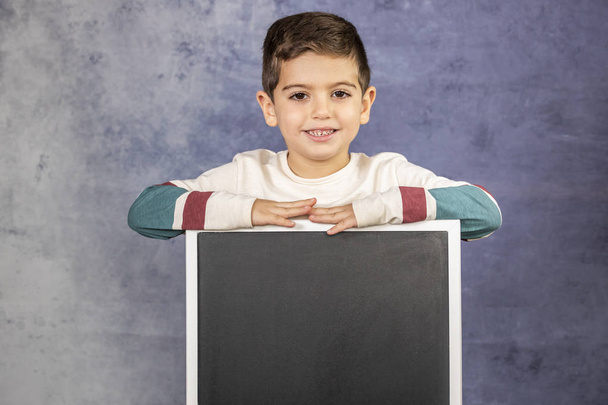 Little boy holding an empty black board - Φωτογραφία, εικόνα