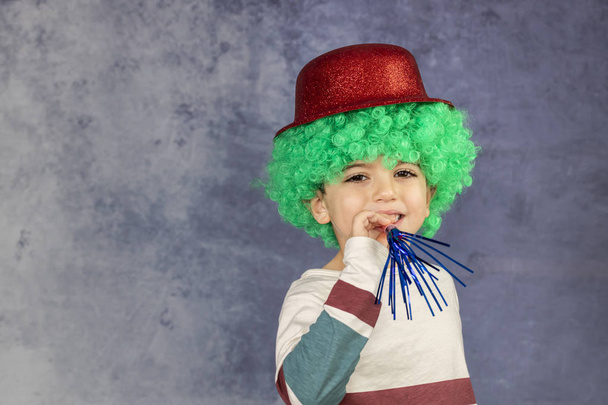 Маленький мальчик в зеленом парике, красной шляпе и галстуке-бабочке
 - Фото, изображение