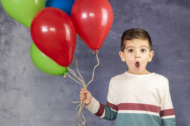 Cute kid holding a lot of balloons - Photo, Image