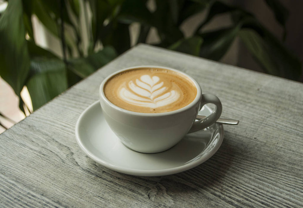 Een kopje koffie in een café met prachtige latte art. - Foto, afbeelding