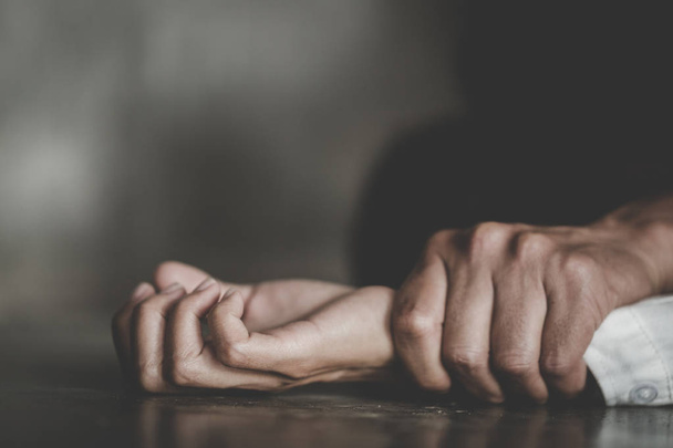 Το χέρι ενός άνδρα που κρατά ένα χέρι γυναίκας για βιασμό και σεξουαλική κακοποίηση έννοια, Πληγωμένη ενδοοικογενειακή βία βιασμού, φωτογραφία έννοια της σεξουαλικής επίθεσης, Παγκόσμια Ημέρα της Γυναίκας - Φωτογραφία, εικόνα