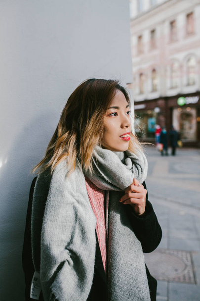 Asian girl looks in profile on the street - Fotó, kép