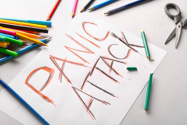 Papír s textem panická ataka a barevné tužky na bílém pozadí - Fotografie, Obrázek