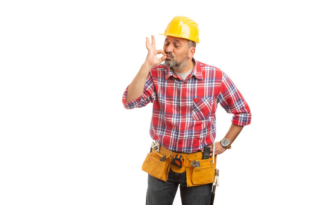 Man builder kissing tip of fingers as good job perfect concept isolated on white studio background - Photo, Image