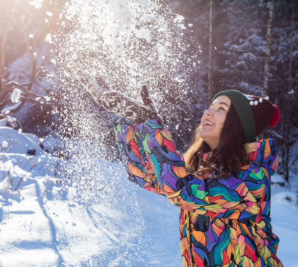 Feliz inverno divertido mulher jogando bandeira de neve. Panorama colheita de estilo de vida ao ar livre menina jogando na neve do lado de fora rindo em casaco amarelo, chapéu, luvas e cachecol
. - Foto, Imagem