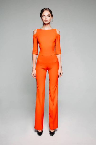 großes Modell in lässigem orangefarbenem Overall und High Heels. - Foto, Bild