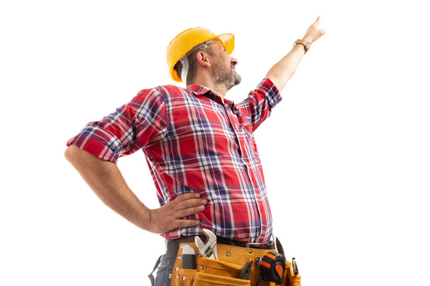 Abaixo foto do construtor masculino apontando para cima com o dedo indicador isolado no fundo do estúdio branco
 - Foto, Imagem