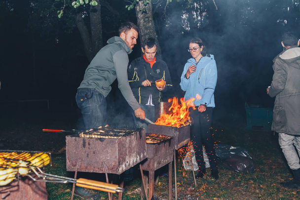 September, 29, 2018 - Minsk, Belarus: Quest on sights of Belarus, group of people making bbq party at night - Foto, afbeelding