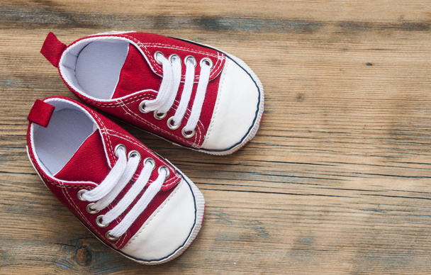 colorful shoes for a small baby on a wooden background. View from above - Φωτογραφία, εικόνα