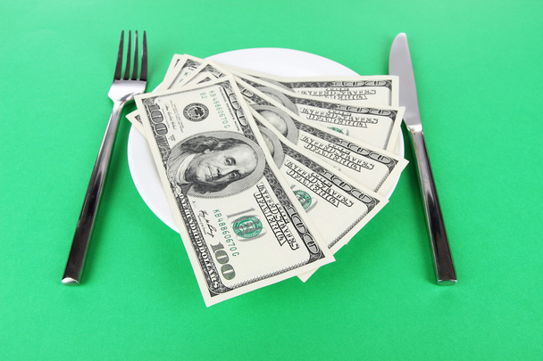 Money on plate on green background - 写真・画像