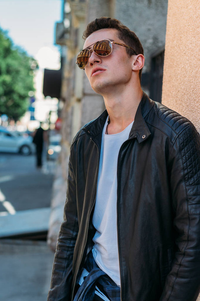 Attractive, sexy guy standing on the street in sunglasses. self-confidence, flatulence and arrogance.model, posing, portrait of a young man - Foto, Imagem
