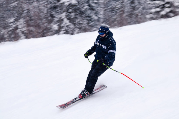 Rusia, Sheregesh 2018.11.18 Esquiador profesional en ropa deportiva brillante y equipo de esquí cuesta abajo en las altas montañas soleadas nevadas. Desenfoque, enfoque suave, objeto en movimiento. Concepto de descanso seguro
 - Foto, imagen