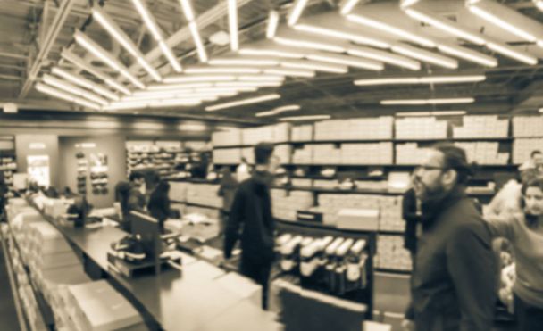 Vintage loja de sapatos desfocados tom com cliente lotado tentando novos sapatos, botas, tênis. Desfocado movimento ocupado pessoas fazendo compras na tomada em Texas, EUA
 - Foto, Imagem