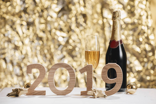 Bruisend Nieuwjaar achtergrond met champagne glazen fles en houten nummers 2019 - Foto, afbeelding