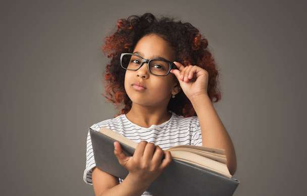 Маленька чорна дівчинка читає книгу
 - Фото, зображення