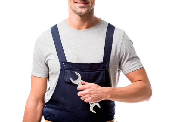 cropped view of mechanic in overalls holding wrench isolated on white - Valokuva, kuva