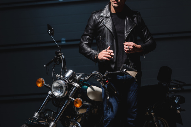 обрізаний вид хлопця, що стоїть на мотоциклі в гаражі
 - Фото, зображення