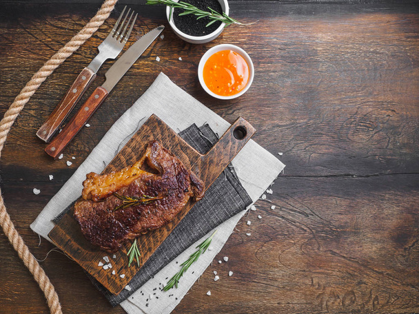 Ribeye stake with spices on the wooden board. - Photo, Image