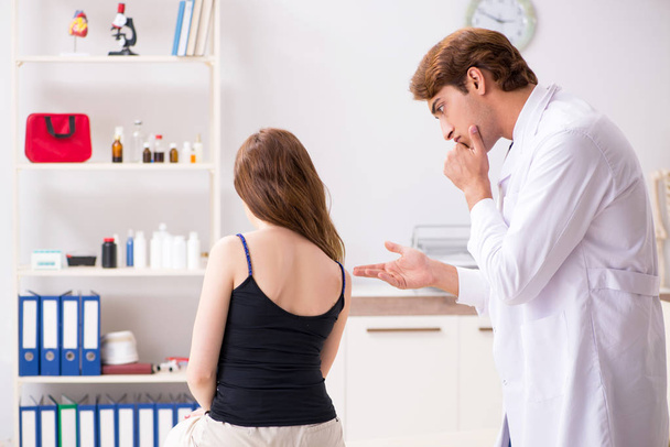 Female patient visiting young handsome doctor chiropractor  - Foto, Imagem